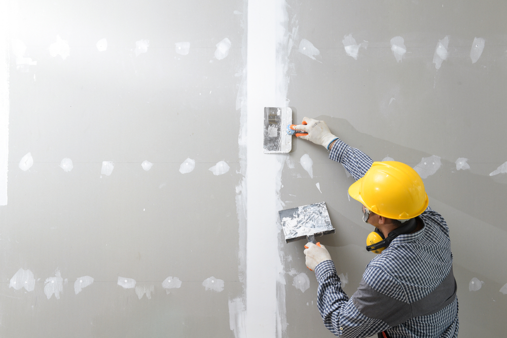 a drywaller patching a wall after installing the drywall