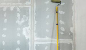 Drywall With Paint Roller Leaning Against The Wall